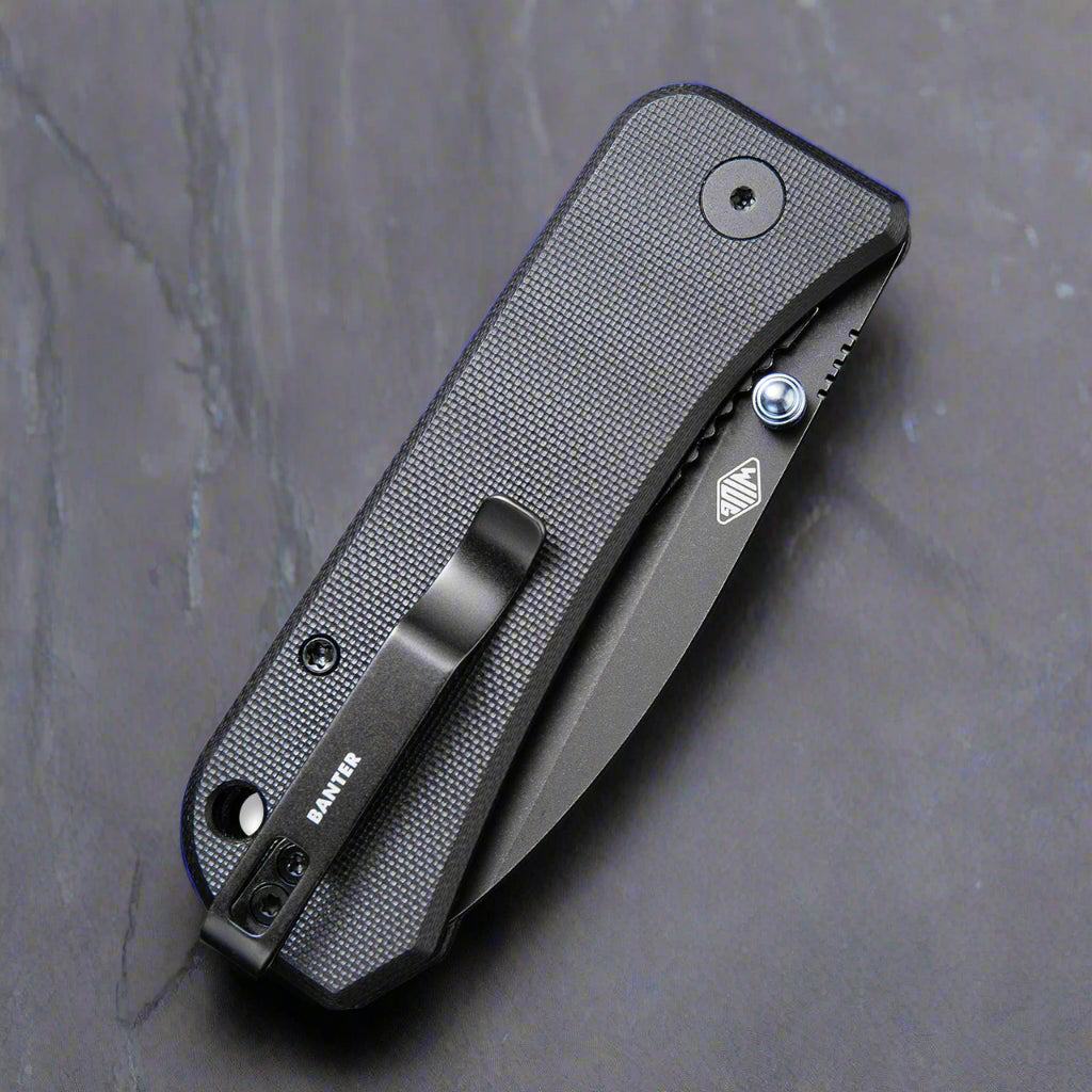 folded Banter G10 folding knife from the side, showing "BANTER" logo on the pocket clips, hole at the end of the handle for rope, G10 handle, and thumbstud.